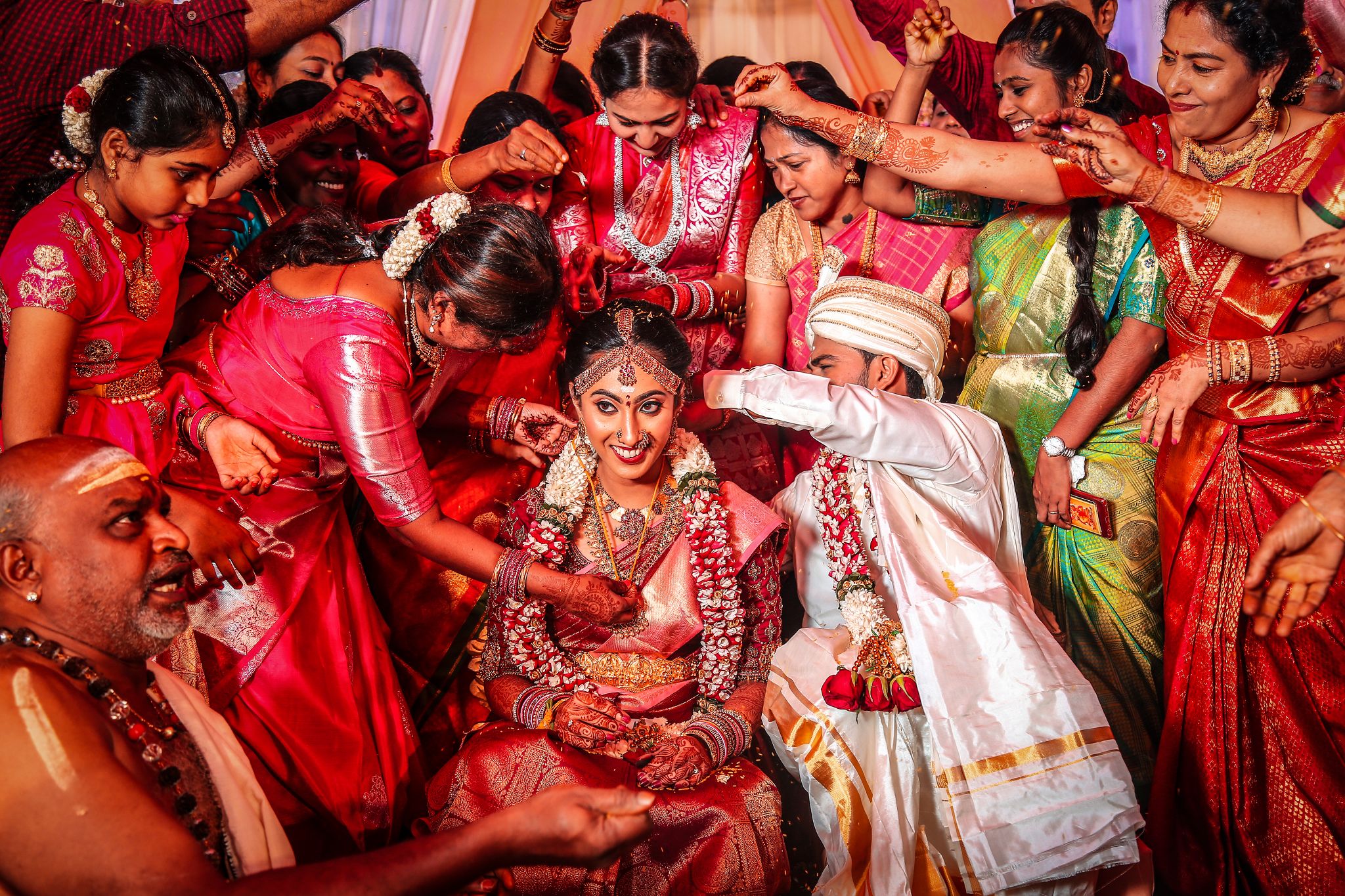 Family blessing bride and groom on stage during wedding reception in Coimbatore
